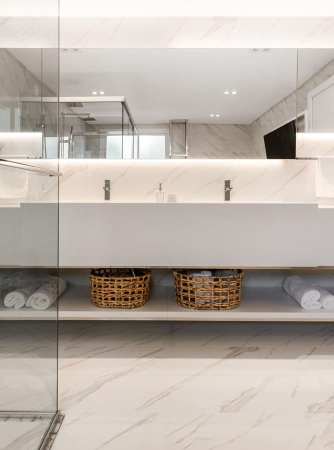 Double vanity with a long mirror cabinet and woven baskets on an open shelf