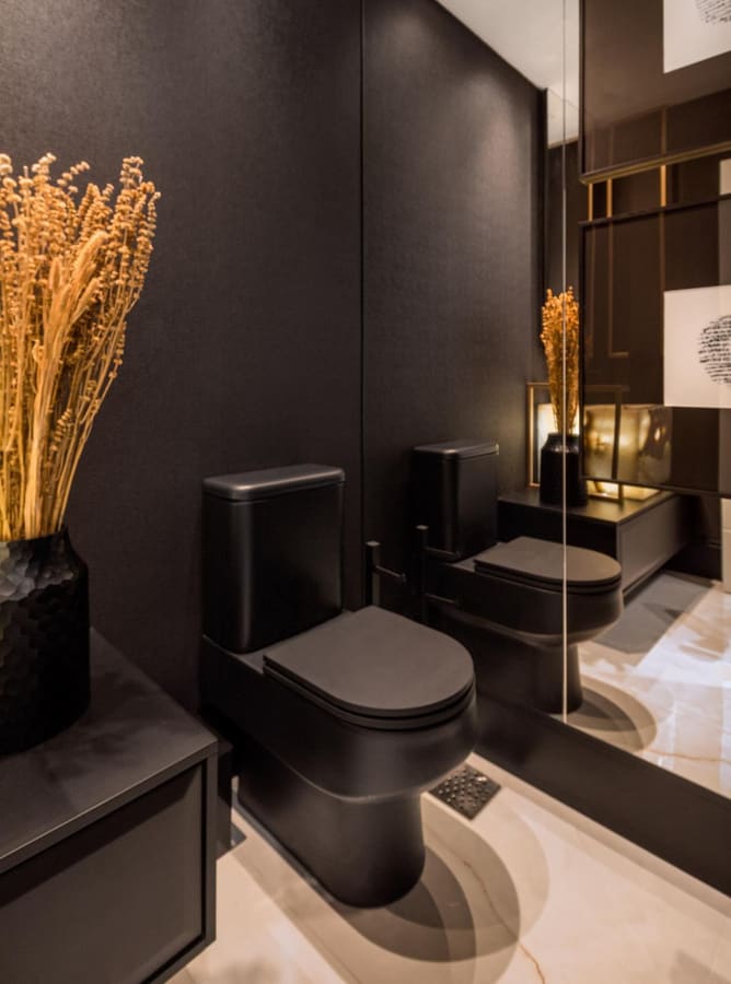 Dark powder room with a black wall-hung toilet, a mirror wall and dried flowers