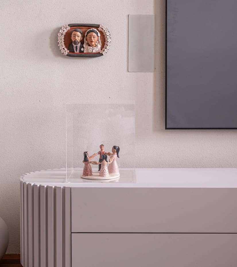 Fluted white media console with display pieces under a wall-mounted TV