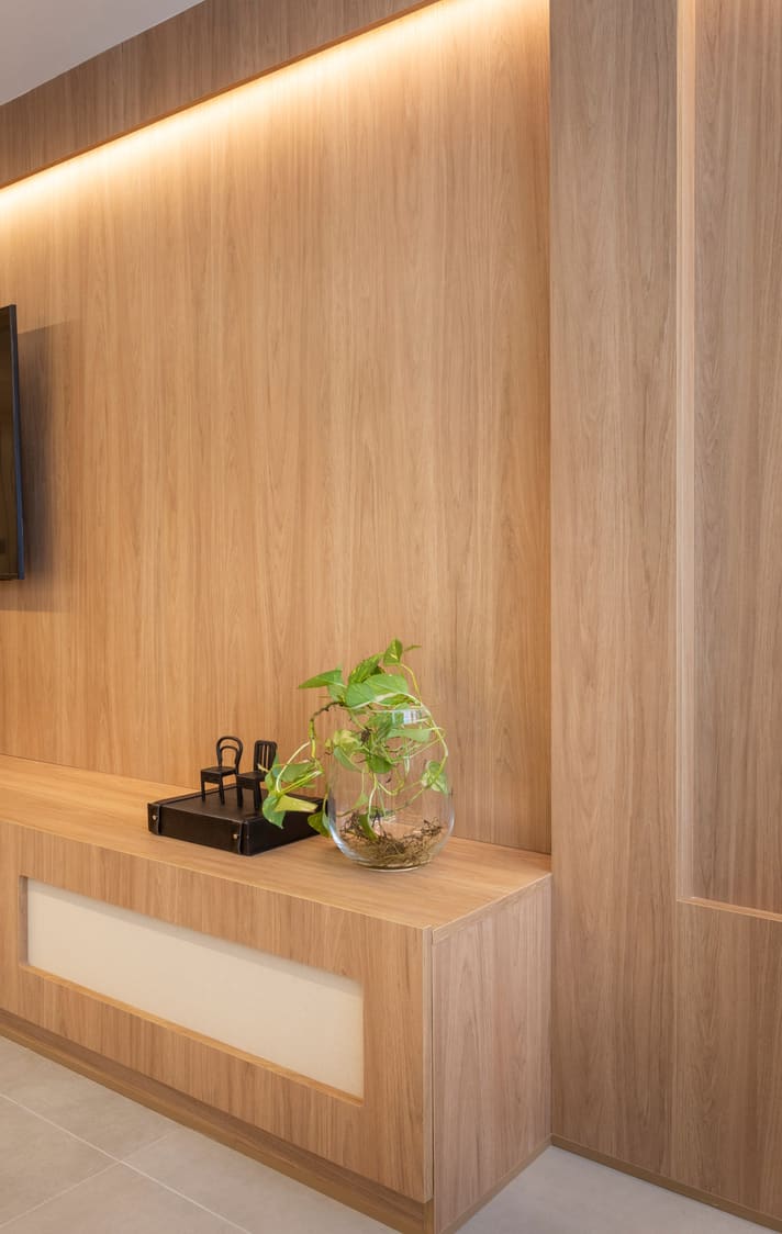Wood-paneled wall with a lit reveal and a cane-front console