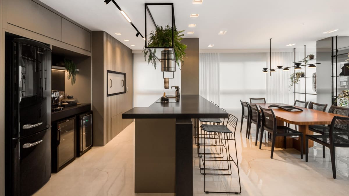 Kitchen and dining room with a dark island, a suspended planter and a long table by the windows