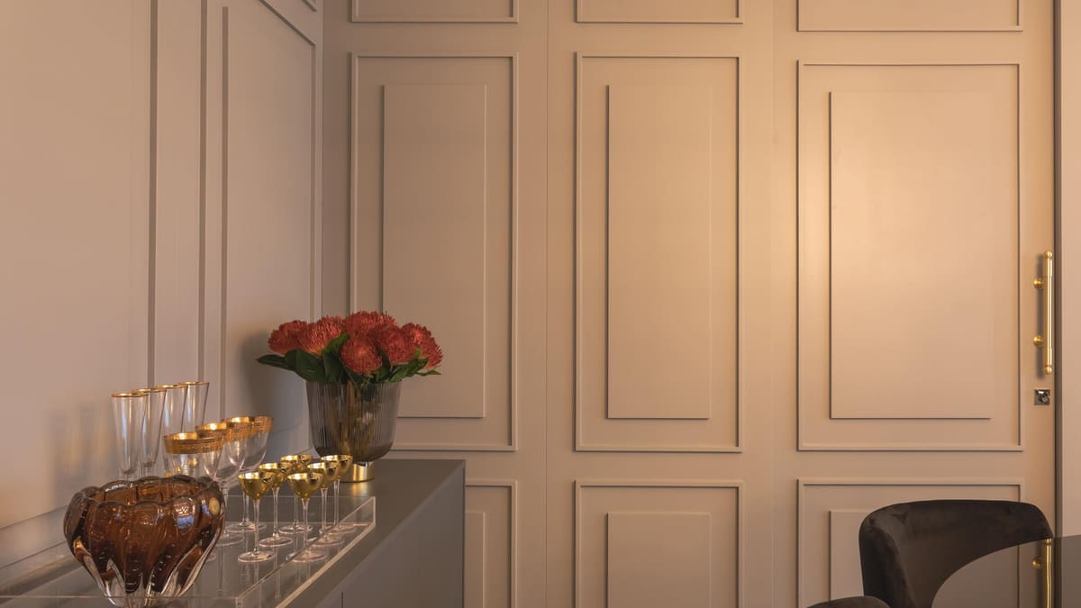 Molded wall panels with a concealed door and a glassware sideboard