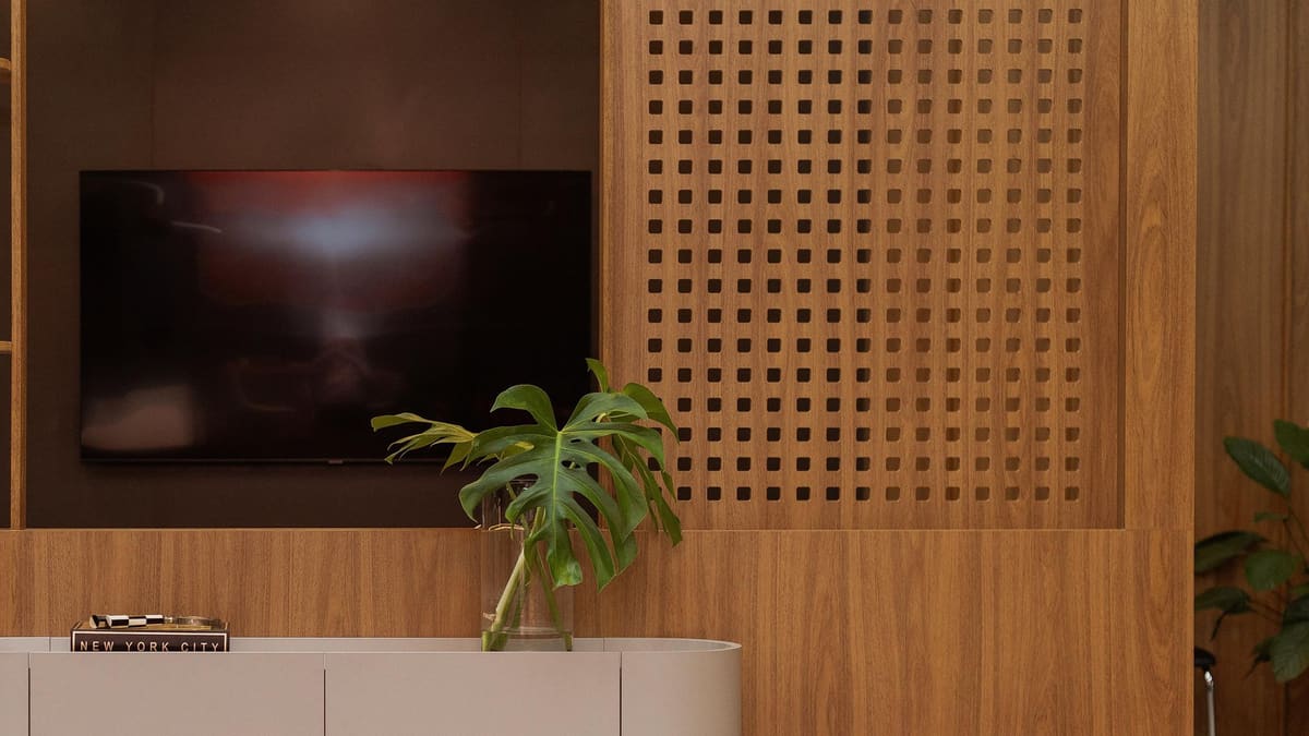 Media wall with a perforated wood panel and a low sideboard