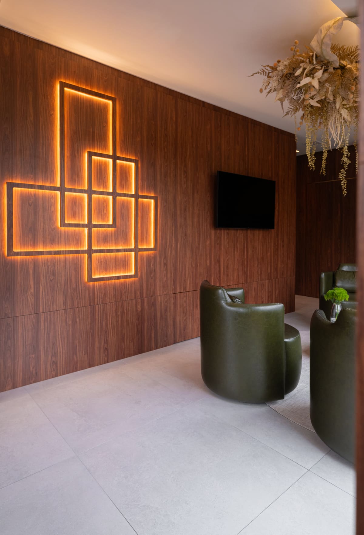 Lounge with walnut wall panels and backlit geometric inlays